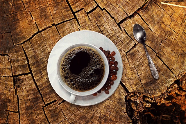 An overhead picture of a cup of dark coffee on a sawn off stump