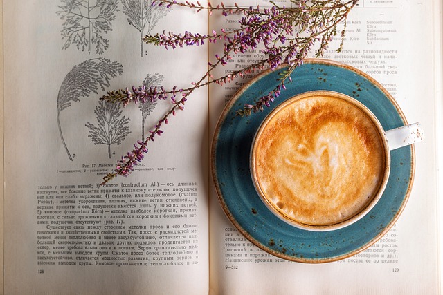 Cappuccino and a sprig of lavender on a book opened to page about flowers