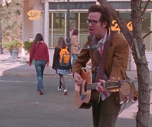GLP standing on a corner, strumming in his way
