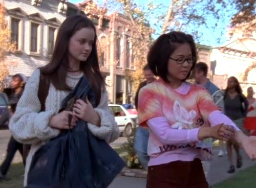 Lane putting a Woodstock 99 tee shirt over her pink thermal tee